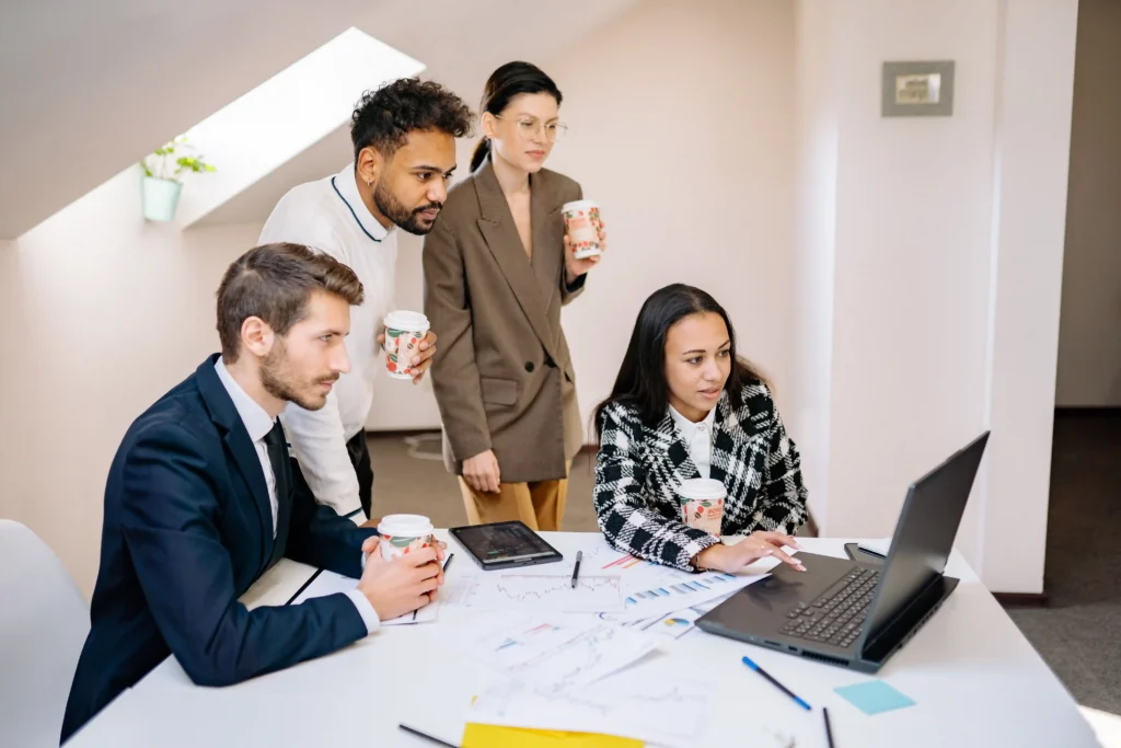 A group of business professionals collaborating around a conference table in a modern office setting.