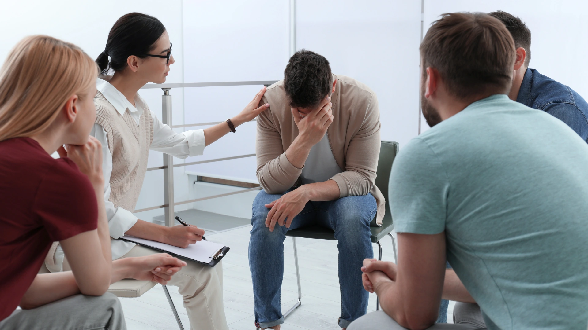 A diverse group of people seated in a circle, engaged in discussion or sharing ideas.
